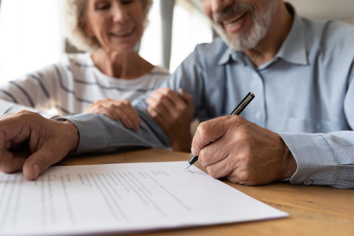 happy old couple signing an estate planning agreement