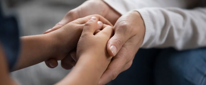 close-up of a father's hands holding his child fighting for child custody