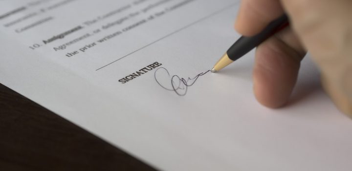 closeup of a man signing his signature on the acknowledgement of paternity forms
